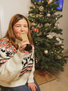 Lauren Cowie - young woman drinking a cocktail in front of her christmas tree